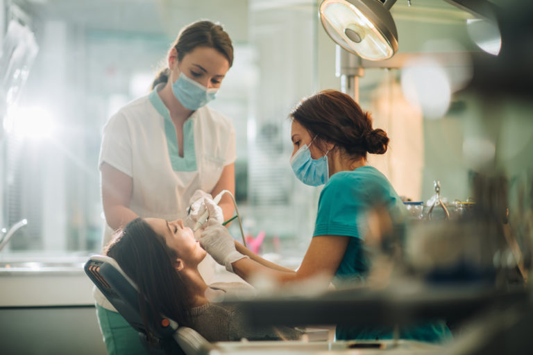 auxiliar de medicina dentária a prestar assistência durante consulta