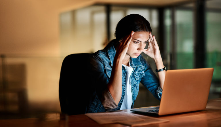 rapariga em frente ao portátil sob stress para ilustrar inteligência emocional pouco desenvolvida