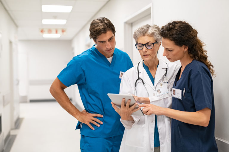 auxiliar de saúde a conversar com médico e enfermeiro